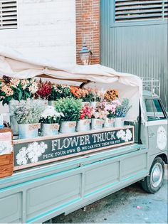 a truck with flowers on the back parked in front of a building