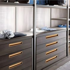 an image of a bedroom setting with clothes on the shelves and dressers in the room