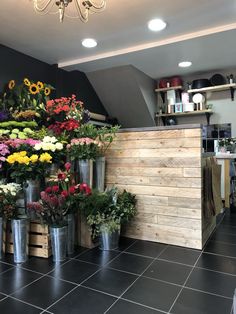 a flower shop with flowers in buckets on the counter