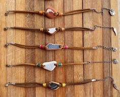 several different types of beaded items on a wooden table with chains hanging from them