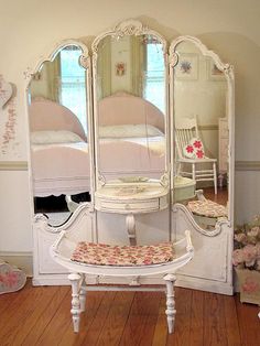 a white vanity with mirror and stool in a room