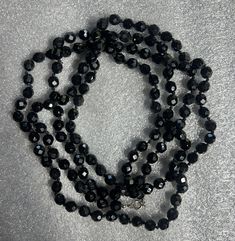 Make a statement with this stunning Vintage Opera Length Necklace featuring large black faceted hematite beads. The elegant opera length adds a touch of sophistication to any outfit, while the faceted hematite beads catch the light for added sparkle and glamour. Perfect for both casual and formal occasions, this necklace is a timeless piece that will elevate your style with its classic beauty. Necklace measures approximately 60 inches long when unclasped. Elegant Black Faceted Beads, Formal Black Faceted Beaded Necklaces, Formal Black Faceted Beaded Necklace, Formal Black Beaded Necklace With Faceted Beads, Black Faceted Beaded Necklaces For Party, Black Beaded Necklace With Faceted Beads For Evening, Black Faceted Beaded Necklaces, Black Faceted Round Beaded Necklaces, Beauty Necklace