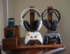 two video game controllers sitting on top of a wooden table next to other gaming accessories