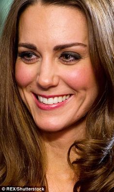 a close up of a person wearing a black dress and smiling at the camera with other people in the background