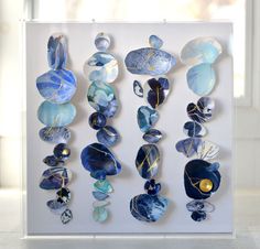 a group of glass pieces hanging on a wall next to a white window sill