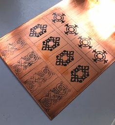 a close up of a wooden board with designs on it