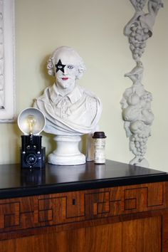 a white busturine sitting on top of a wooden dresser