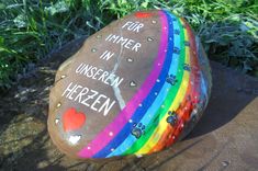 a painted rock with the words fur immer in unseren herzen on it