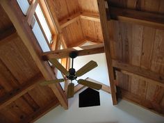 an overhead view of a ceiling fan in a room with wood paneling and windows