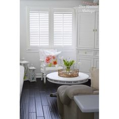 a living room filled with furniture and white shuttered windows covered in blinds on top of them