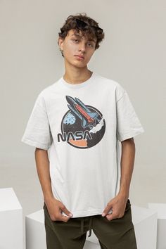 The Space Shuttle, a true icon for any aspiring space traveler! These graphics are retro and futuristic at the same time. This tee will remind anyone around you that there is a whole universe out there beyond the Earth. Blast off! ✅ Blank tee - our favorite Bella+Canvas 3001 ✅ 100% Airlume combed and ring-spun cotton ✅ Unisex fit, true to size ✅ Soft and comfortable ✅ Pre-shrunk fabric ✅ Printed in the USA with water-based, non-toxic ink Retro Crew Neck Pre-shrunk Top, Space-themed Graphic Print Cotton T-shirt, Space-themed Cotton T-shirt With Graphic Print, Space-themed Graphic Print Short Sleeve Tops, Space-themed Short Sleeve Top With Graphic Print, Vintage Logo Print T-shirt, Space-themed Graphic Crew Neck Tops, Retro Cotton Crew Neck T-shirt, Space-themed Short Sleeve Screen Print Top