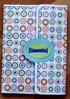 an open notebook with a name on the front and colorful circles in the back, sitting on a wooden table