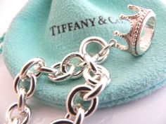 Offered for sale is a wonderful Tiffany and Co. Sterling Silver Crown Charm bracelet. The piece is made from substantial and bright Tiffany silver, and yet retains a very feminine feel to it. Attached to its very substantial Tiffany Silver charm bracelet is a fantastic and whimsical Crown charm. The charm is attached to the bracelet with a Sterling Silver Tiffany Clasp - this clasp opens and closes and thus can be used as a charm on a necklace or as part of another charm bracelet! Super versatil Princess Bracelet, Crown Charm, Charm Chain, Silver Crown, Silver Charm Bracelet, Tiffany And Co, Gift Pouch, Bracelet Bangle, Crown Princess