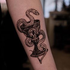 a tattoo on the arm of a woman with a snake wrapped around her neck and head