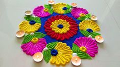 a colorful flower design with candles on the floor