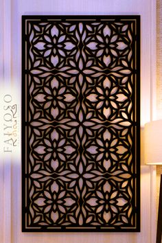 an intricately designed metal screen in the corner of a room with lamps on either side