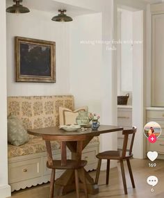 a table and two chairs in a room with white walls, wood flooring and built - in cabinets