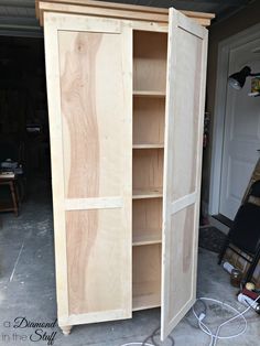 a tall wooden cabinet sitting inside of a garage