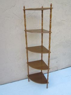 a wooden shelf with three shelves on each side and two legs at the top, against a white wall