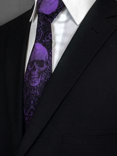 a man wearing a purple tie with a skull on it's lapel collar