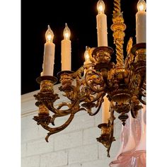 an ornate chandelier with candles lit up in the dark night sky behind it