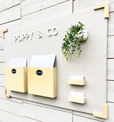 the sign for poppy & co is next to a potted plant and mailbox