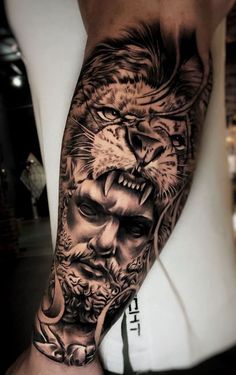 a man's arm with a lion and demon tattoo on the left side of his arm