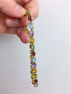 Beautiful vintage 14K Gold bracelet that has a lot of bling loke a rainbow around your wrist. Each gemstone is cut in a pear shape and faceted to reflect light and sparkle. Light green Peridot, red/orange Garnet, blue Topaz, purple Amethyst, and yellow Citrine repeat to create the circle of colors, a Rainbow. Each of the 28 stones measure 4 mm X 6mm. Set in 14k Gold prongs each stone rests in a double basket to let even more light in the sides. The bracelet is linked with small box shaped links. Multi Gemstone Bracelet, Rainbow Gemstones, Marcasite Ring, Bracelet Wedding, Dope Jewelry, Yellow Citrine, Birthstone Bracelets, Green Peridot, 14k White Gold Ring