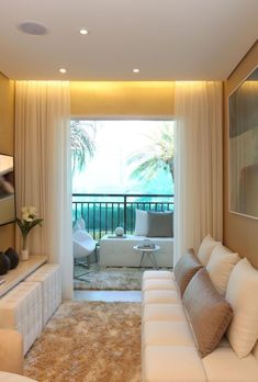 a living room filled with furniture and a window covered in white drapes next to a balcony