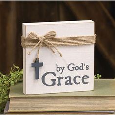 a book with a cross tied to it sitting on top of a stack of books