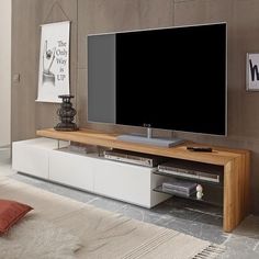 a flat screen tv sitting on top of a white entertainment center in a living room