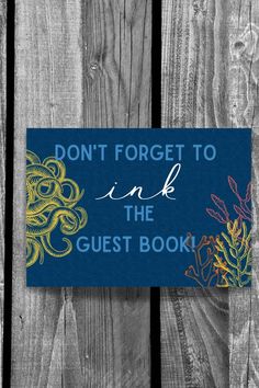 a blue sign that says don't forget to ink the guest book on it