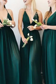 three beautiful women in long green dresses standing next to each other and smiling at one another