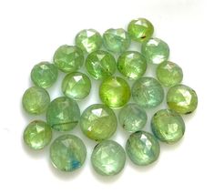 many green glass beads on a white surface