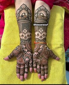 two hands with henna tattoos on them, one is showing off the intricate design