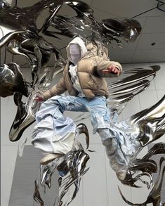 a man is jumping through the air in front of metal sculptures