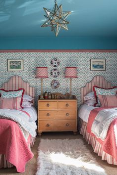 two twin beds in a bedroom with pink and white bedding