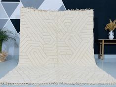 a large white rug sitting on top of a blue floor next to a wooden table