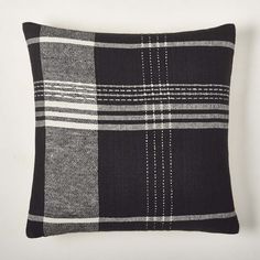 a black and white plaid pillow sitting on top of a table