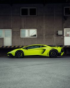 a bright yellow sports car parked in front of a building with no doors on it