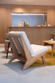 a wooden chair sitting on top of a white rug in a living room next to a table