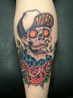 a skull with a hat and roses on it's leg is shown in this image