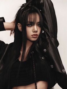 a woman with long black hair wearing a leather jacket