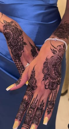 a woman's hands with henna tattoos on them