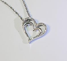 Eye-catching double heart shaped pendant on an Italian chain.  The heart pendant and the Italian chain are both made of sterling silver.  The outer heart shaped piece of the pendant has a row of diamonds running across the top of the heart and down part of each side.  This necklace will bring attention to the person wearing it.  The chain for the necklace goes through the side of the heart allowing it to slide nicely on the chain.  This necklace and pendant will show your special someone just ho Silver Double Heart Necklace With Heart Detail, Silver Double Heart Necklace With Heart Beads, Silver Heart Pendant Necklace For Anniversary, Silver Heart Cut Jewelry With Heart Detail, Heart-shaped Silver Chain Jewelry For Anniversary, Silver Chain Necklace With Heart Pendant For Anniversary, Double Heart Sterling Silver Jewelry With Heart Detail, Anniversary Necklace With Silver Chain And Heart Pendant, Anniversary Necklace With Heart Pendant And Silver Chain