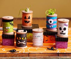 several spools of thread with halloween decorations on them sitting on a table next to each other