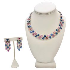 A handmade 89.98 Total Carat Sapphire and 26.98 Total Carat Diamond Necklace and Earrings Set This one-of-a-kind multicolor necklace and earrings boasts Natural, Sapphires from Sri Lanka. The set highlights the beautiful interplay of the rare fancy pink sapphires with blue sapphires. The stones are strewn together with "flower” shaped diamonds links made with marquise and round cut diamonds. All the stones are prong set securely in quality platinum. The necklace clasp is discreet, designed to take nothing away from its perfect form.  Wear together or on their own, the necklace and earrings set are sure to turn heads. Specifications: - 17 Inch Length necklace - Diamonds: F-G Color and VS Clarity, 26.98 total carat weight - Fancy Pink and Blue Sapphires from Sri Lanka, 89.98 total carat weig Diamond Necklace And Earrings Set, Diamond Necklace And Earrings, Multicolor Necklace, Necklace Clasp, Necklace Clasps, Length Necklace, Necklace And Earrings Set, Necklace And Earrings, Pink Sapphire