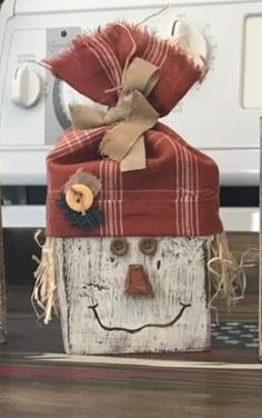 a close up of a wooden block with a scarecrow face on it's head