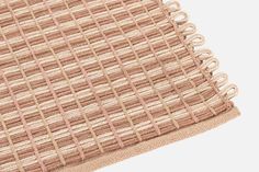 a close up view of the side of a rug with pink and beige squares on it