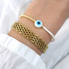 This listing is for the adjustable evil eye beaded bracelet ONLY. Evil Eye Beaded Bracelet, Adjustable Beaded Bracelet, Evil Eye Protection Bracelet, Delicate Beaded Bracelet, Evil Eye Jewelry, Mal de Ojo ♥ DESCRIPTION:        This bracelet is perfect for everyday wearing and for any outfit.    Looks beautiful alone or as stacking bracelet.     ♥   Adjustable     ♥ MATERIAL & SIZE:    Seed beads in gold and white, Adjustable bracelet.             ♥ PROCESSING TIME:    Our current processing time Adjustable Beaded Evil Eye Bracelet, Elegant Gold Beaded Evil Eye Bracelet, Elegant Beaded Evil Eye Bracelet, Evil Eye Beaded Bracelet, Eveil Eye Sead Bead Bracelet, Affordable Adjustable Hand-strung Evil Eye Bracelet, Protection Bracelet, Eye Protection, Jewelry Cleaner